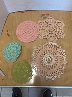 All five handmade crochet doilies on tabletop