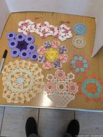 All nine assorted crochet doilies displayed on tabletop