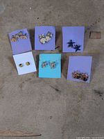 Group photo showing all six pairs of earrings on colored cards