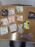 Group shot of all sealed toys and two plush pieces on table