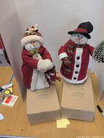 Both Avon snow couple figurines standing on boxes