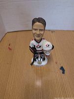 Front view of hockey player bobblehead on wooden surface