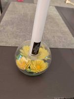 Two round glass candle holders with yellow flowers and white candles