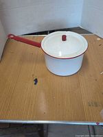 Full view of white enamel saucepan with lid