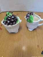 Creamer and sugar bowl front view showing basketweave bodies and grape decorations