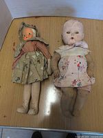 Front view of both dolls side by side on table