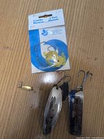Group of four lures including packaged crawler harness and three spoon lures