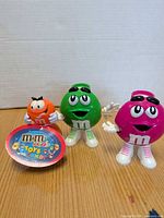 Front view of three M&M's Minis roller ball figures on table