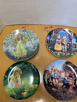 All four child-themed collector plates front view