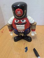 Front view of Red M&M nutcracker dispenser showing overall design
