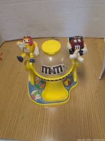 Full view of yellow M&M’s lifeguard dispenser, both character figures visible