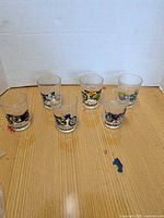 Five of six motorcycle graphic tumblers on table