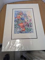 Full view of matted artwork in plastic wrap