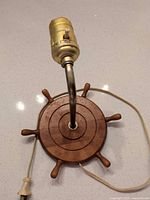 Top view showing wooden ship wheel base, brass socket, cord