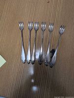 Six forks laid out on table