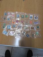 Group shot of all 30 individually bagged stamps spread on tabletop