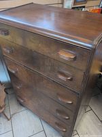 Front view showing five drawers, pulls, waterfall corners