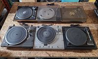 All six turntables laid out on tabletop, cables visible