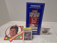 Group shot showing Clemens plaque, Primestar display, playing card deck, and stack of loose cards