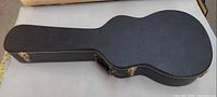 Closed black hard guitar case exterior showing overall condition