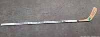 Entire stick showing autograph on blade and commemorative text along shaft