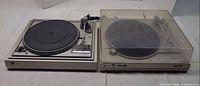 Dual 505 and CS 607 turntables side by side, dust covers shown