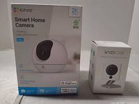 Retail boxes for EZVIZ C6C and Wyze Cam shown together