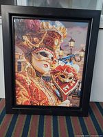Front view of framed printed canvas showing carnival mask artwork