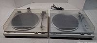 Both JVC turntables side by side with dust covers closed