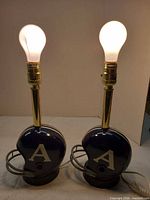 Front view of both helmet lamps with bulbs lit showing overall design and condition