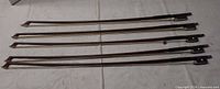 Five violin bows laid flat full view