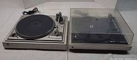 Both Dual turntables side by side; 505 on left, 506 with dust cover on right, RCA cable visible