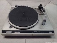 Top view of Technics SL-Q2 turntable with dust cover open, platter, tonearm and control panel visible