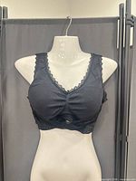 Front view of lace-trim black bralette on mannequin