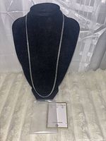 Full view of silver-tone chain on display bust