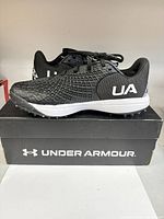 Full side view of the shoes on original Under Armour box