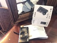 Camera, box and manuals on table