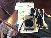 Camera, manuals, charger, cable, pouch, lens attachment