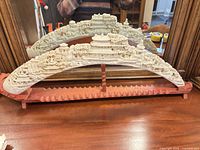 Full view of composite landscape carving on wooden stand with mirror reflection