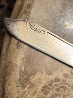 Knife tip showing decorative scroll pattern