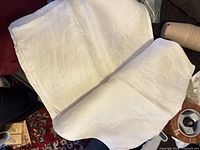 white linen tablecloths folded on couch