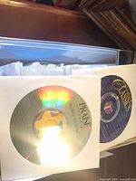 Two discs in paper sleeves labeled Praise and Classics on top of stack of paper-sleeved discs