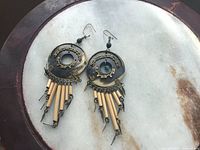 Front view of pair 1 showing disc, filigree, tubular dangles, brass chain