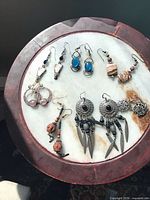 All seven pairs of earrings displayed on round surface