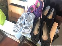 All four pairs of shoes grouped: sandals, sneakers, flats, slip-ons