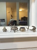 Group shot of all four miniature silver items