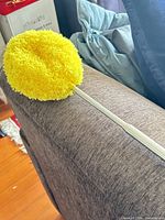 Yellow microfiber duster on sofa arm