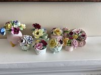 All nine bone china floral ornaments on shelf