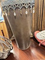 Full view of brown metal plant stand and partial basket