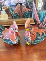 pair of carved wood rooster figurines front view